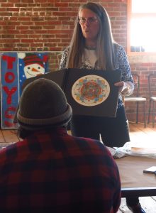 Instructor Sue Aripotch shows the class her work